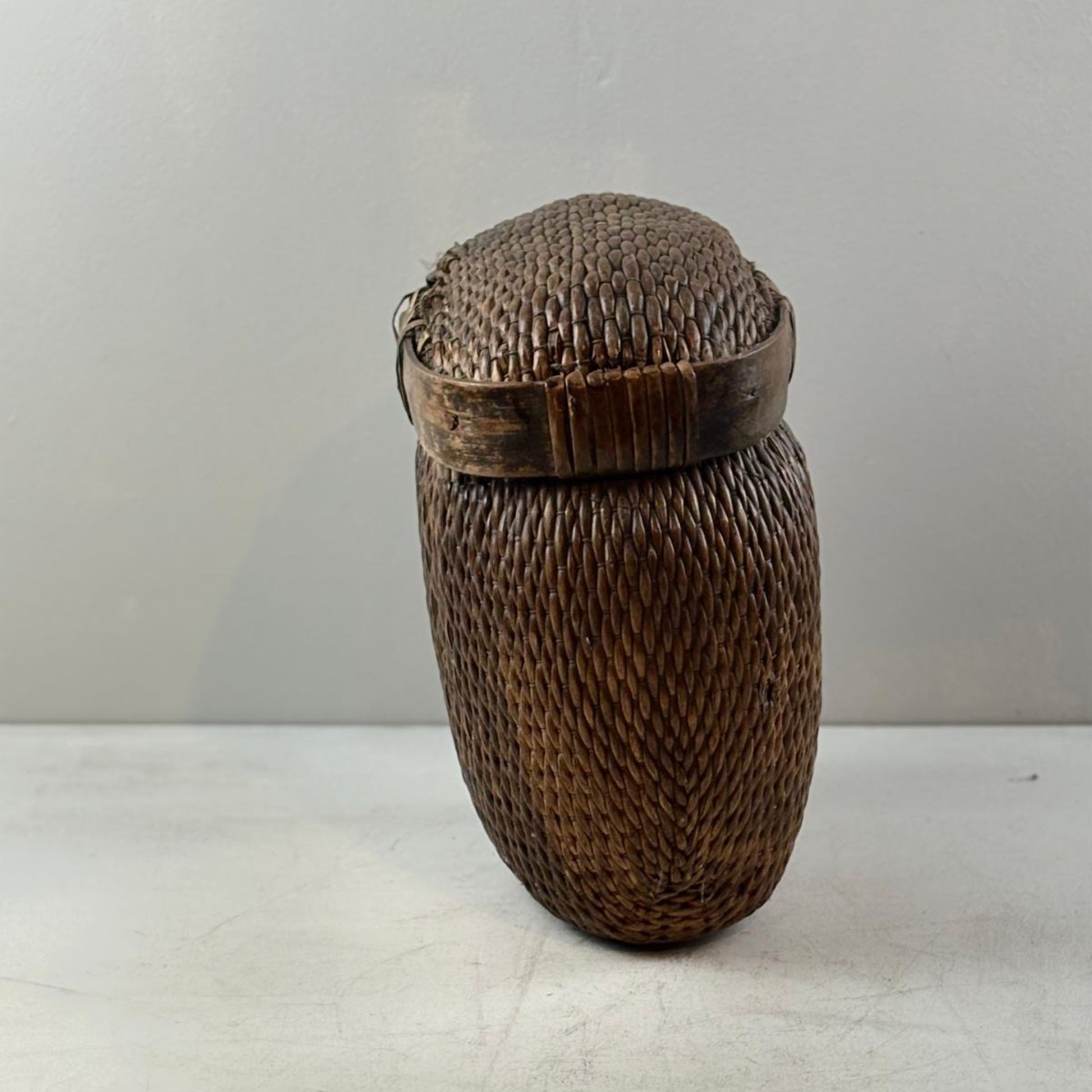 Woven basket with a lid on a white background